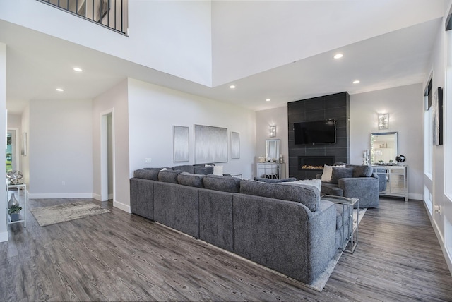 104 Highview Ct, Brooklyn, MI 49230 - living room with recessed lighting, baseboards, dark wood-type flooring, a large fireplace, and a high ceiling
