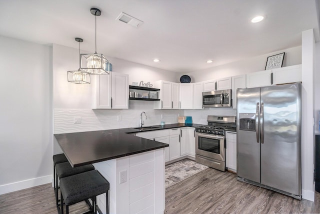 104 Highview Ct, Brooklyn, MI 49230 - kitchen with stainless steel appliances, a sink, a peninsula, dark countertops, and open shelves