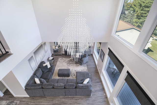 104 Highview Ct, Brooklyn, MI 49230 - living area with a towering ceiling, a chandelier, wood finished floors, and baseboards