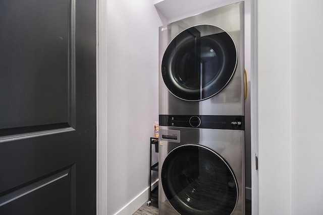 104 Highview Ct, Brooklyn, MI 49230 - laundry area with stacked washer and clothes dryer, wood finished floors, and baseboards