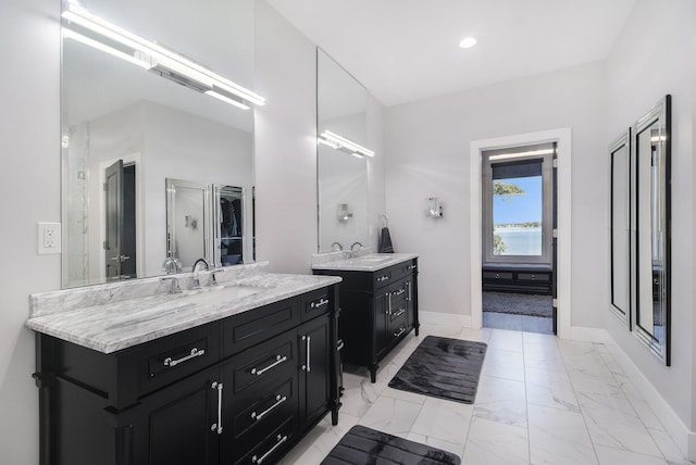 104 Highview Ct, Brooklyn, MI 49230 - bathroom featuring baseboards, two vanities, marble look tiles, and recessed lighting