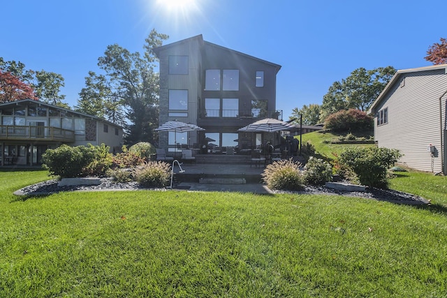 104 Highview Ct, Brooklyn, MI 49230 - back of property featuring a patio area, a lawn, and a balcony