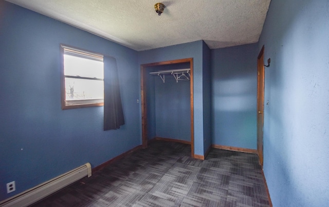 286 S Willowbrook Rd, Coldwater, MI 49036 - unfurnished bedroom with baseboard heating, a textured ceiling, carpet flooring, a closet, and baseboards