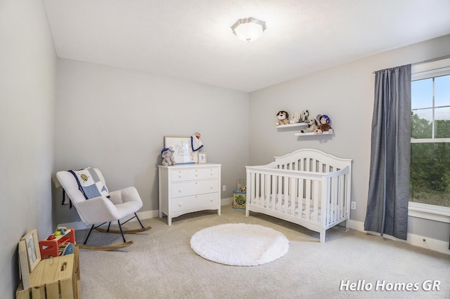 535 N Creek Ct NE, Rockford, MI 49341 - bedroom with a crib, carpet flooring, and baseboards