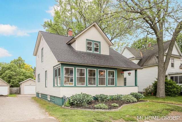 44 Taft St, Zeeland, MI 49464 - view of front of property with a chimney, a shingled roof, an outbuilding, a detached garage, and a front lawn