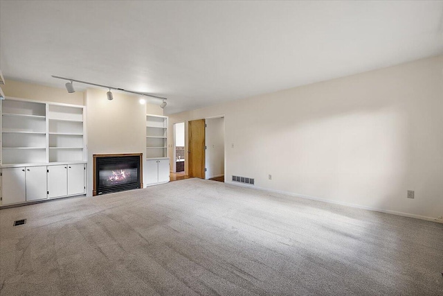 2 Eastbury Ct, Ann Arbor, MI 48105 - unfurnished living room with a glass covered fireplace, carpet, baseboards, and track lighting