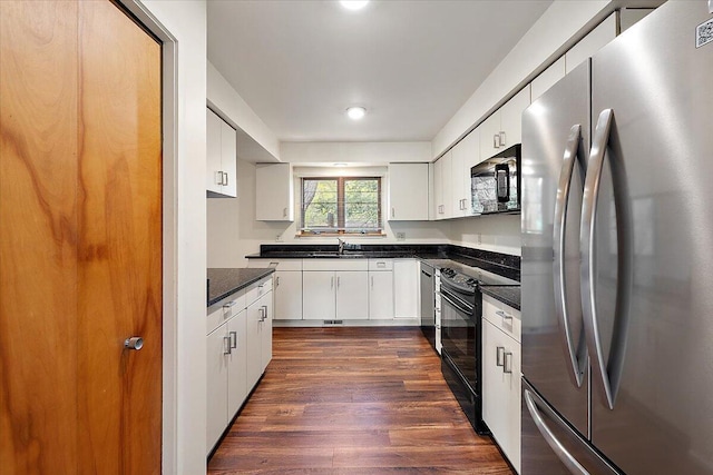 2 Eastbury Ct, Ann Arbor, MI 48105 - kitchen with appliances with stainless steel finishes, dark countertops, a sink, dark wood finished floors, and white cabinets