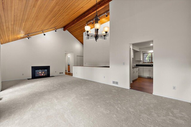 2 Eastbury Ct, Ann Arbor, MI 48105 - unfurnished living room with wooden ceiling with exposed beams, carpet flooring, high vaulted ceiling, baseboards, and a fireplace with flush hearth