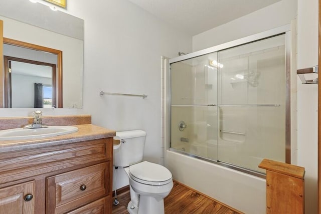 3025 Shawnee Rd, Bridgman, MI 49106 - full bathroom with vanity, toilet, shower / bath combination with glass door, and wood finished floors