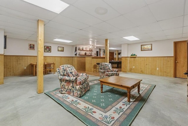 3025 Shawnee Rd, Bridgman, MI 49106 - living area featuring a wainscoted wall, concrete flooring, a drop ceiling, and wood walls