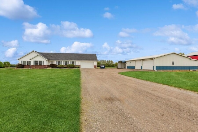 3025 Shawnee Rd, Bridgman, MI 49106 - single story home with dirt driveway, a front lawn, an outbuilding, and an attached garage