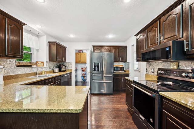 4085 Ravina Ter, Saint Joseph, MI 49085 - kitchen with stainless steel appliances, a sink, dark brown cabinetry, decorative backsplash, and dark wood finished floors