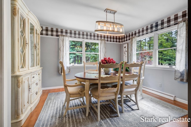 300 N 2nd Ave, Fruitport, MI 49415 - dining space featuring a baseboard radiator, light wood-style flooring, and baseboards
