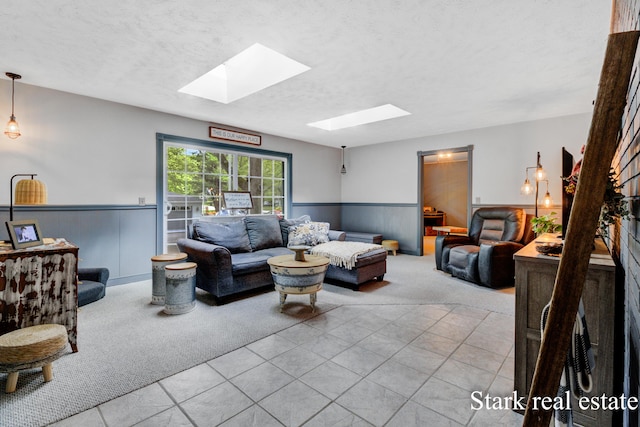 300 N 2nd Ave, Fruitport, MI 49415 - carpeted living area with a skylight, a wainscoted wall, a textured ceiling, and tile patterned flooring