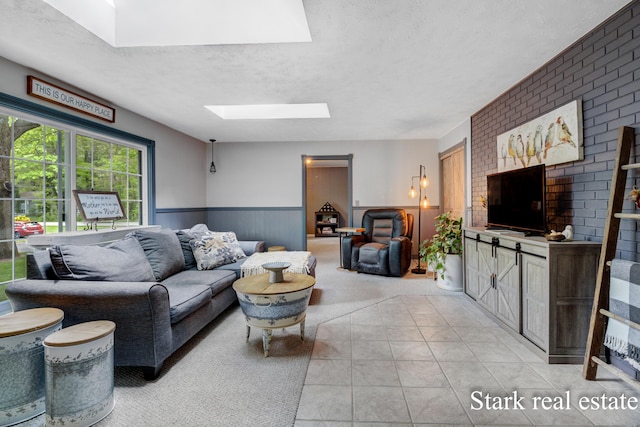 300 N 2nd Ave, Fruitport, MI 49415 - living room featuring a skylight, a wainscoted wall, and a textured ceiling