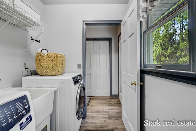 300 N 2nd Ave, Fruitport, MI 49415 - laundry area with separate washer and dryer, healthy amount of natural light, and wood finished floors