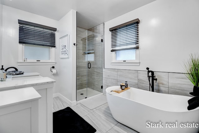 300 N 2nd Ave, Fruitport, MI 49415 - full bath with a freestanding tub, a shower stall, vanity, marble finish floors, and baseboards
