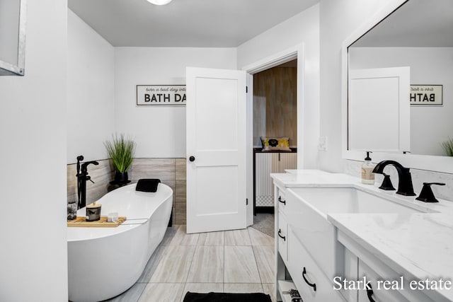 300 N 2nd Ave, Fruitport, MI 49415 - bathroom featuring vanity, a soaking tub, and tile walls