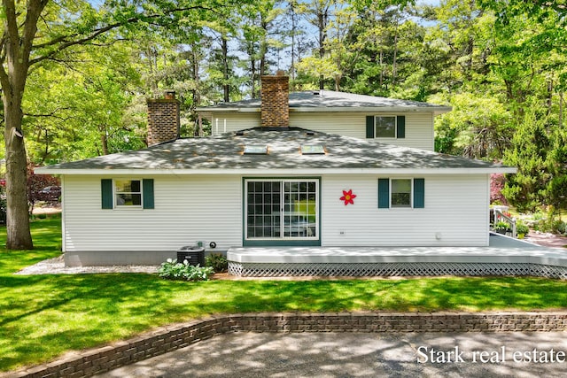 300 N 2nd Ave, Fruitport, MI 49415 - rear view of property featuring a chimney, a deck, and a yard