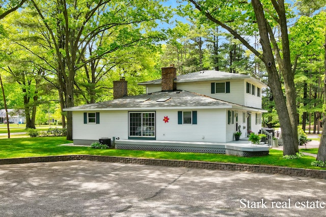 300 N 2nd Ave, Fruitport, MI 49415 - back of property with a chimney, a yard, a deck, view of wooded area, and cooling unit