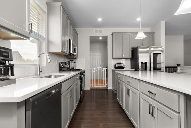 2771 Silo Dr, Saline, MI 48176 - kitchen with appliances with stainless steel finishes, a sink, gray cabinets, dark wood finished floors, and light countertops