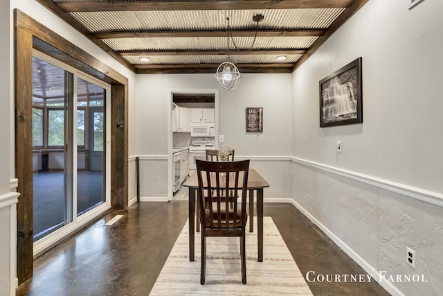 414 135th Ave, Wayland, MI 49348 - dining room featuring concrete flooring, a chandelier, baseboards, a wainscoted wall, and beamed ceiling