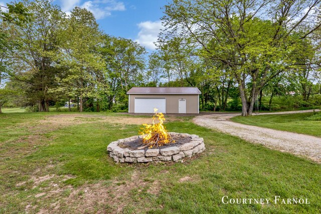 414 135th Ave, Wayland, MI 49348 - view of green lawn featuring a garage, an outdoor structure, a fire pit, and driveway