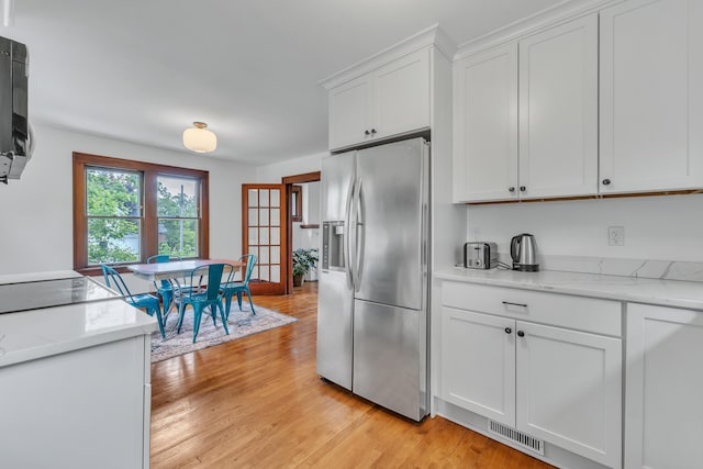 710 S 1st St, Ann Arbor, MI 48103 - kitchen with stainless steel fridge with ice dispenser, white cabinets, light wood-type flooring, light stone countertops, and cooktop