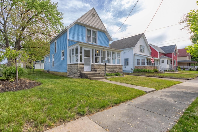 825 Conger St, South Haven, MI 49090 - view of front of property featuring a front yard, entry steps, and a sunroom