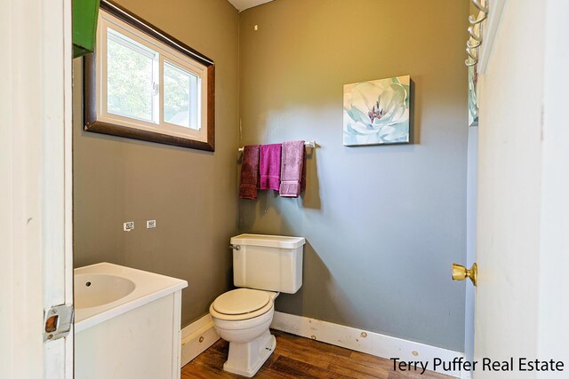 2576 Vine Ave, Muskegon, MI 49442 - bathroom with wood finished floors, toilet, baseboards, and vanity