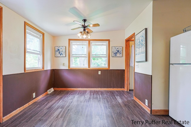 2576 Vine Ave, Muskegon, MI 49442 - unfurnished dining area with wood finished floors, wainscoting, a ceiling fan, baseboards, and wooden walls