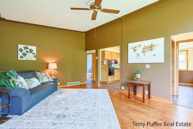 2576 Vine Ave, Muskegon, MI 49442 - living area with baseboards, ceiling fan, light wood-style floors, and a towering ceiling