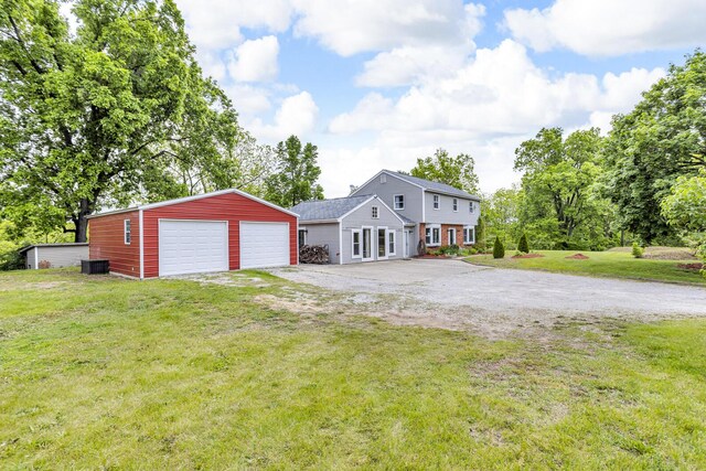 9410 US Highway 12, Brooklyn, MI 49230 - colonial-style house featuring an outbuilding, a front lawn, and a detached garage