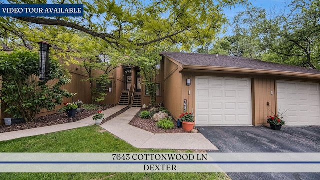 7643 Cottonwood Ln, Dexter, MI 48130 - view of front of home featuring driveway, a garage, and stairway