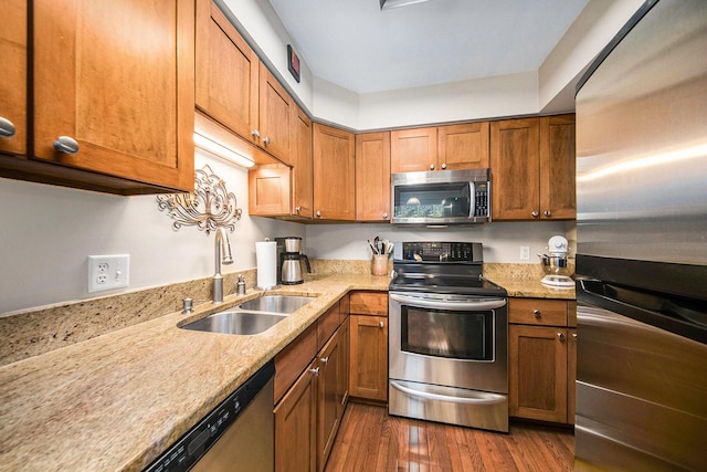 7643 Cottonwood Ln, Dexter, MI 48130 - kitchen with stainless steel appliances, a sink, dark wood-style flooring, and brown cabinets