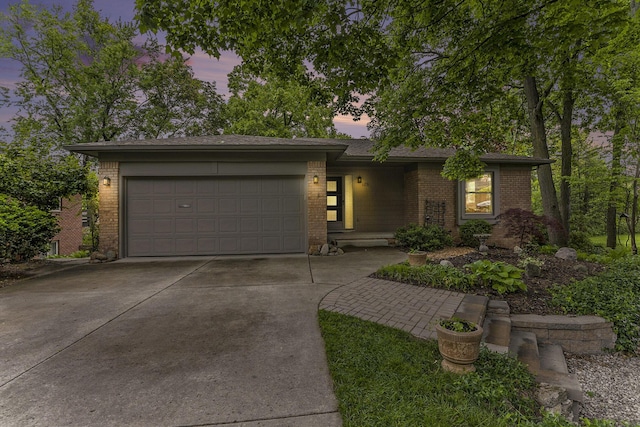 1231 Naples Ct, Ann Arbor, MI 48103 - view of front facade with brick siding, an attached garage, and concrete driveway