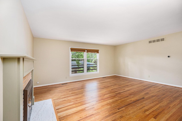 1231 Naples Ct, Ann Arbor, MI 48103 - unfurnished living room with light wood-style flooring, a fireplace with flush hearth, and baseboards