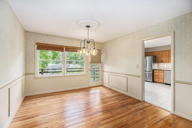 1231 Naples Ct, Ann Arbor, MI 48103 - unfurnished dining area with wallpapered walls, light wood finished floors, and a chandelier