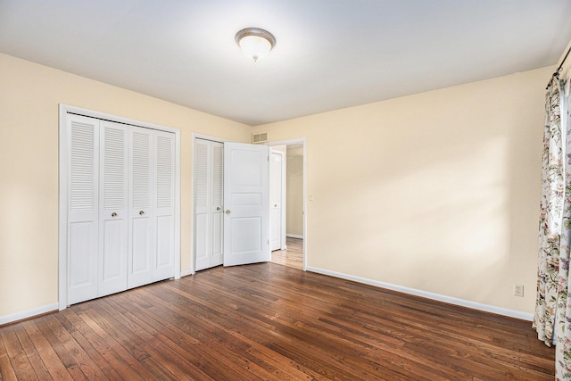 1231 Naples Ct, Ann Arbor, MI 48103 - unfurnished bedroom featuring multiple closets, dark wood finished floors, and baseboards
