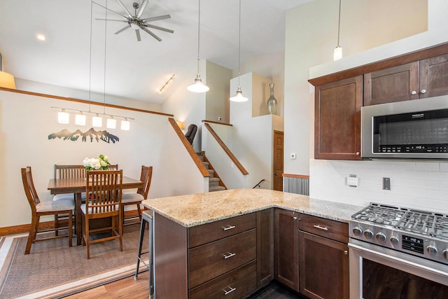 9324 Perry St, Zeeland, MI 49464 - kitchen featuring appliances with stainless steel finishes, a peninsula, ceiling fan, dark brown cabinetry, and wood finished floors