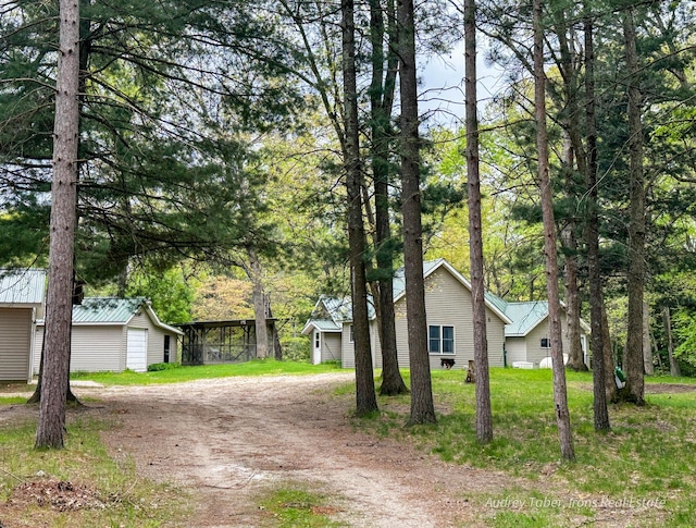 4307 N Mac Rd, Irons, MI 49644 - view of front facade featuring driveway, an outbuilding, and a garage
