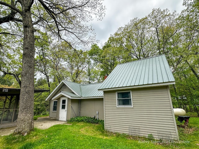 4307 N Mac Rd, Irons, MI 49644 - rear view of property featuring metal roof, a yard, and a chimney