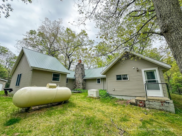 4307 N Mac Rd, Irons, MI 49644 - view of side of property with a yard, metal roof, and a chimney