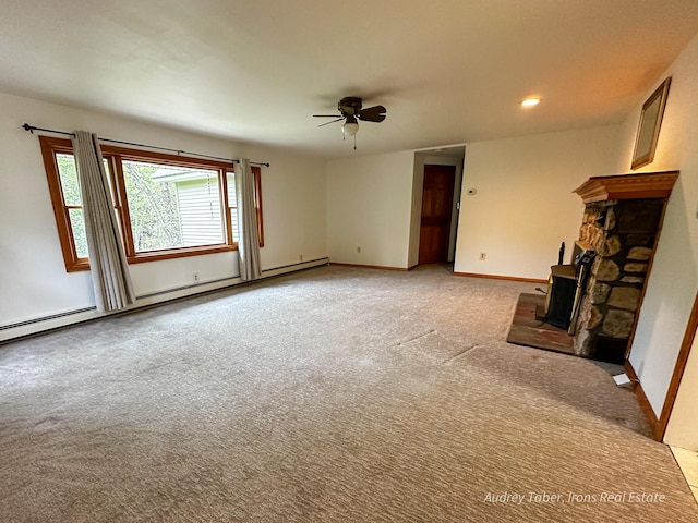 4307 N Mac Rd, Irons, MI 49644 - unfurnished living room featuring a ceiling fan, light colored carpet, baseboard heating, a stone fireplace, and baseboards