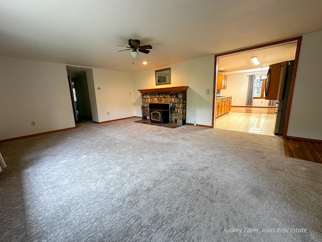 4307 N Mac Rd, Irons, MI 49644 - unfurnished living room featuring ceiling fan, light carpet, a fireplace, and baseboards