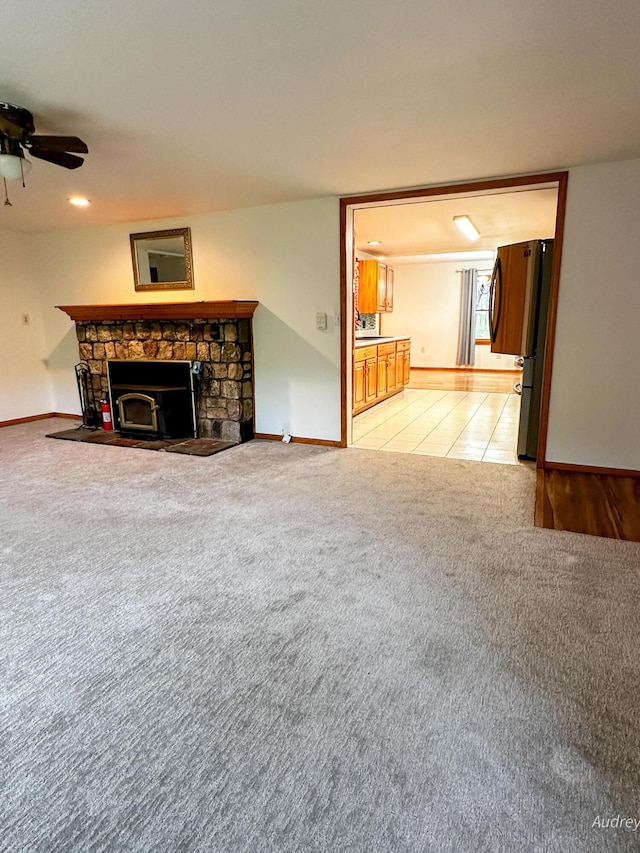 4307 N Mac Rd, Irons, MI 49644 - unfurnished living room with light colored carpet, a fireplace, a ceiling fan, and baseboards