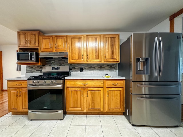 4307 N Mac Rd, Irons, MI 49644 - kitchen featuring appliances with stainless steel finishes, under cabinet range hood, light countertops, and brown cabinets