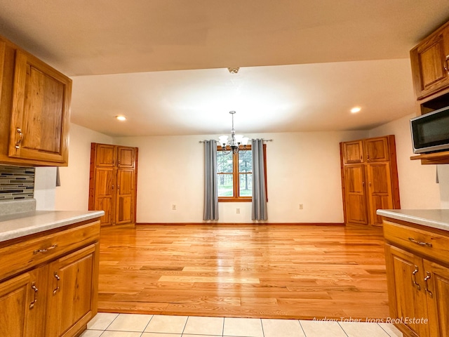 4307 N Mac Rd, Irons, MI 49644 - kitchen with brown cabinets, a chandelier, light countertops, and recessed lighting