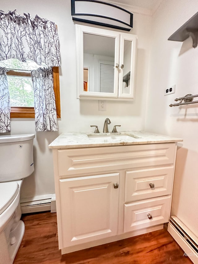 4307 N Mac Rd, Irons, MI 49644 - half bath featuring a baseboard heating unit, a baseboard radiator, toilet, wood finished floors, and vanity