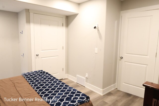 239 Monroe Ave, Muskegon, MI 49441 - bedroom with light wood finished floors, baseboards, and a closet